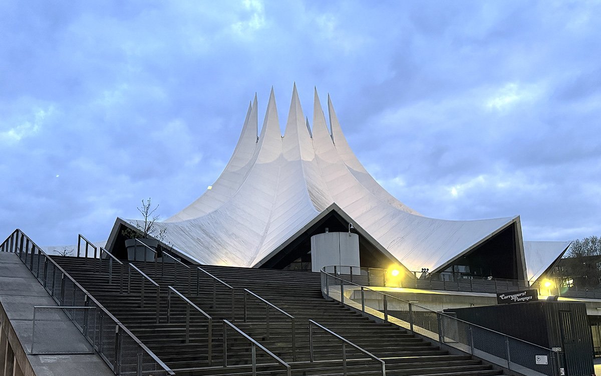 Exterior del Tempodrom de Berlín, con su techo puntiagudo que imita una carpa, y la escalinata de entrada